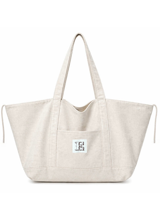 Stone color linen tote bag with a small white label on a white background